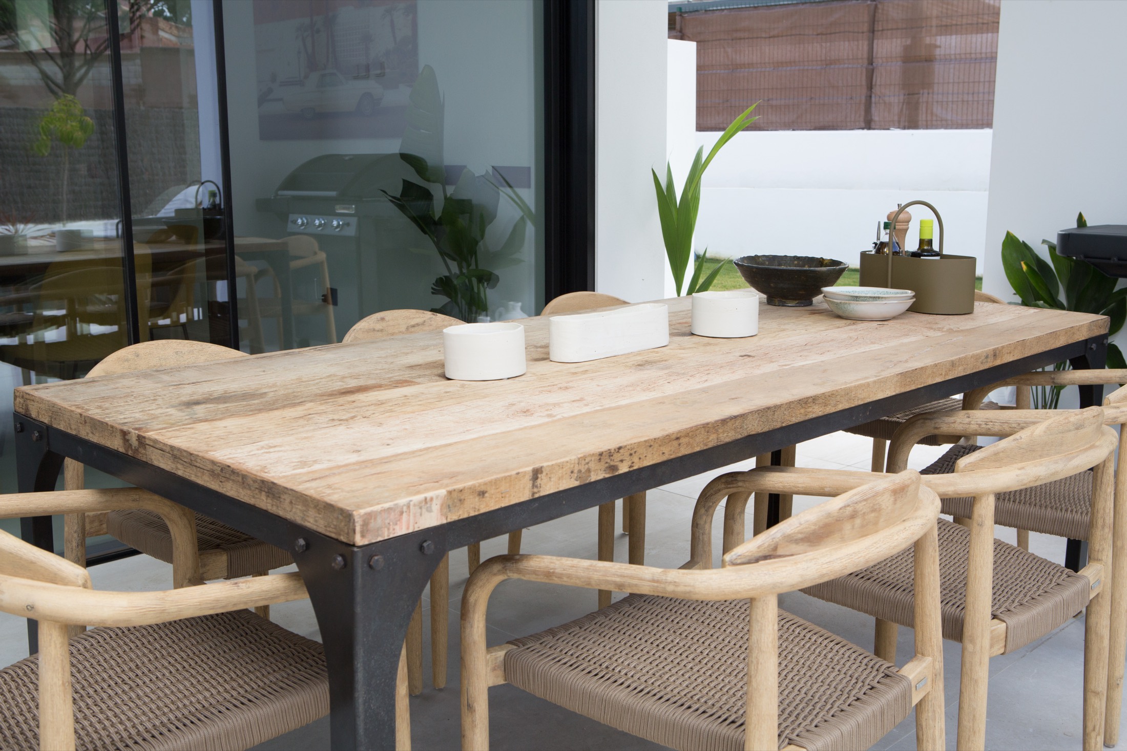 A long outdoor dining table set on a VIVLA home terrace